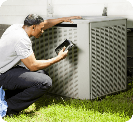 Technician performing maintenance on an air conditioning unit outside of a home