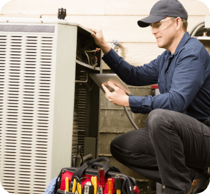 Maintenance man looking at an air conditioning unit