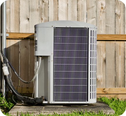 Air conditioning unit outside of house next to a fence