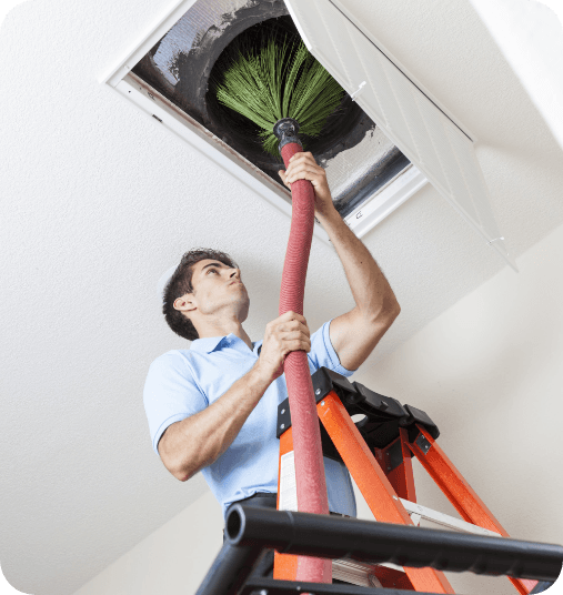 Man using machine to clean air duct in ceiling